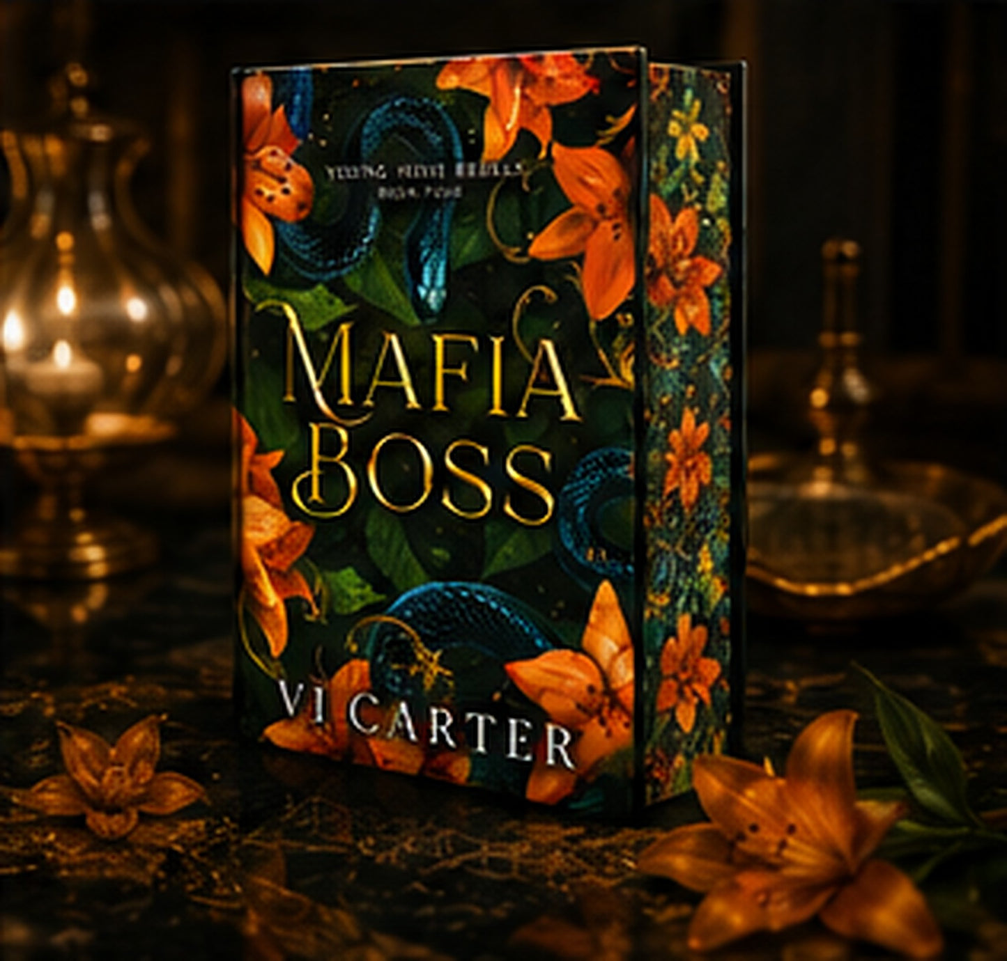 A boxed book or book set titled "Mafia Boss" by Vi Carter, shown standing upright on a dark surface with ornate brass lamps and flowers around it. The cover art features dark green and black tones with orange flowers, blue snakes, and gold lettering.